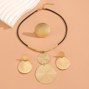 Detailed view of 4-piece gold jewelry set with hammered texture and black cord necklace