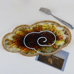 Detailed top view of a cloud-shaped resin tray with golden foil and white swirl patterns