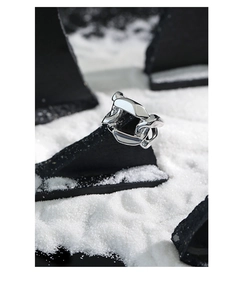 Close-up of wide S925 sterling silver chain ring on a black stone with salt background
