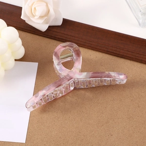 Pink marble texture hair claw clip shown in a cozy aesthetic setting with white roses