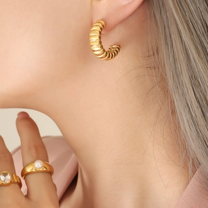 Golden threaded croissant earrings and pearl ring set on model with a warm aesthetic