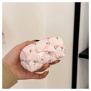 Detailed view of a mini pink floral quilted cotton makeup bag with bow decoration