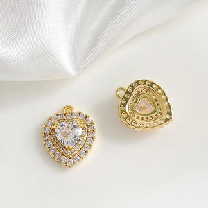 Détail d'un pendentif cœur plaqué or 18k serti de zircons sur de la soie blanche