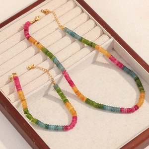 Macro detail of 18K gold plated lobster clasps on colorful tourmaline beaded bracelets