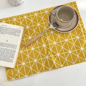 Set de table rectangulaire jaune avec motifs triangles géométriques sur table blanche
