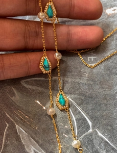 Close-up of 18K gold plated necklace with turquoise pendants and freshwater pearls