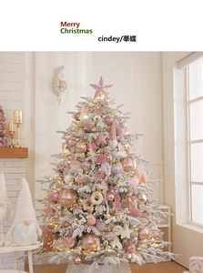 Detailed close-up of a pink flocked Christmas tree with luxury ornaments and a white fence