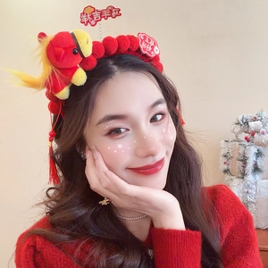 Close-up of festive red plush headband with lucky tassels and decorative charms