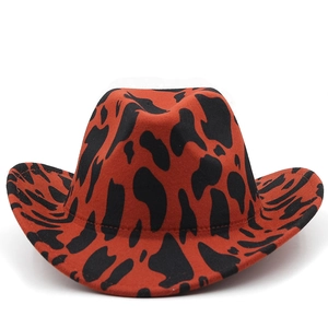 Detailed texture of red cow pattern felt on a classic western cowboy hat with curved brim