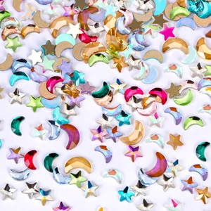 Macro shot of colorful moon and star shaped nail art rhinestones on a white surface