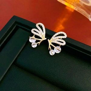 Gold-plated butterfly stud earrings with sparkling cubic zirconia on green leather