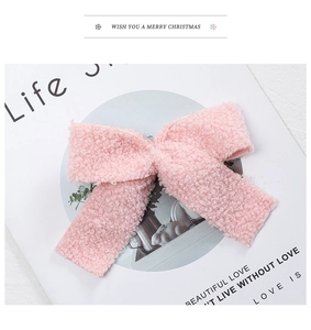 Detailed close-up of pink plush bow ornament made of soft teddy velvet material