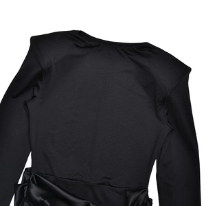 Detail of the elegant black crew neck dress featuring side knot and draped fabric textures