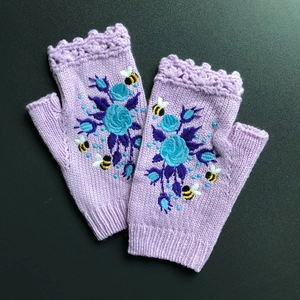 Close-up of lavender knitted fingerless gloves with blue floral and bee embroidery