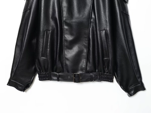 Close-up of black leather jacket belt buckle and textured grain finish details
