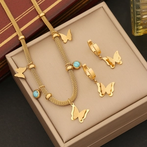 Golden butterfly jewelry set with turquoise beads on a luxury beige gift box