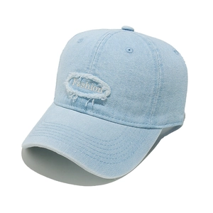 Detail of light blue denim baseball cap featuring distressed Fashion letter embroidery