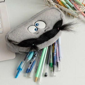 Close-up of fuzzy grey plush pencil case with cartoon eyes and 3D whiskers