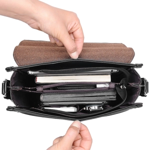Black PU leather crossbody bag with multiple compartments showing large interior capacity