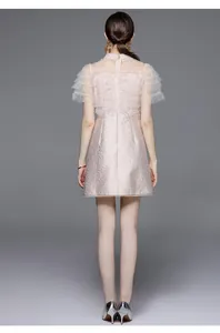 Macro shot of tiered lace sleeves with sequins and pearl trim on pink jacquard dress