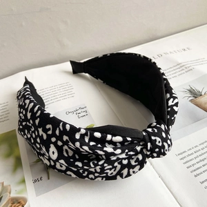 Detail shot of a black and white leopard print knotted headband on an open magazine