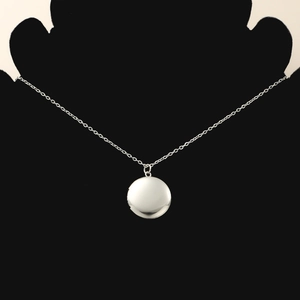 Detailed view of mirror-polished round locket pendant on a delicate chain necklace