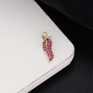 Detail of red gemstone-encrusted chili pepper pendant in 18K gold plated finish