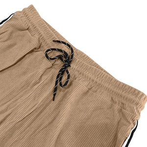 Close-up of khaki corduroy pants showing elastic waistband and striped drawstring detail