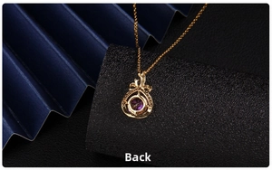 Detailed back view of golden heart necklace pendant with purple zircon and bow detail
