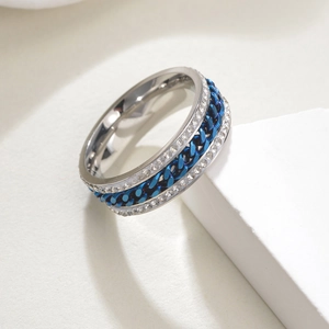 Détail d'une bague rotative en acier inoxydable avec double rangée de diamants et chaîne bleue