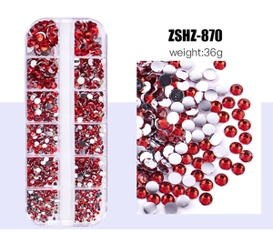 Macro detail of red flatback rhinestones in a 12-grid organizer box for nail art