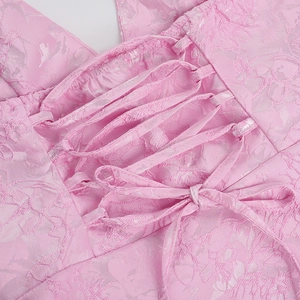 Detail of pink floral jacquard fabric with criss-cross lace-up design and fine texture