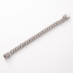Bracelet à mailles cubaines argenté avec strass brillants sur fond blanc épuré
