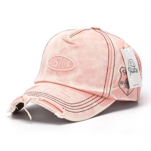 Detailed close-up of distressed denim baseball cap with Boston embroidery and frayed brim