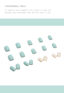 Detail of mint green press-on nails featuring glitter finish and 3D heart accents