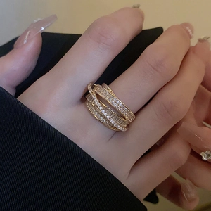 Detail of layered gold zircon ring showing crisscross design and sparkling baguette stones