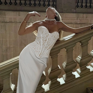 Detail of white lace corset top with floral embroidery and structured boning design