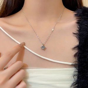 Close-up of sparkling butterfly necklace with a light blue gem on a woman's collarbone