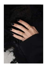 Nahaufnahme von minimalistischen Gold- und Silberringen mit Textur an Fingern