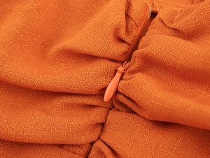 Gros plan sur la robe d'été en lin orange avec détail de fermeture éclair invisible