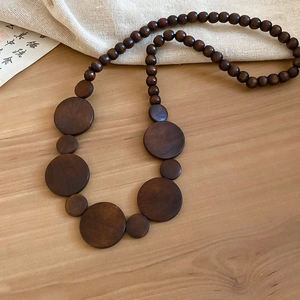 Detailed view of vintage brown wooden beads and geometric pendant necklace with natural grain