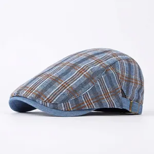 Gorra clásica a cuadros azul y marrón con hebilla de metal sobre fondo blanco