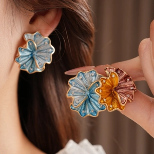 Macro shot of vintage floral enamel earrings and ring set with embedded crystals