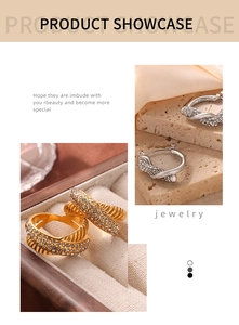 Detailed macro view of twisted gold and silver hoop earrings with sparkling rhinestones
