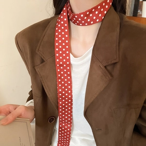 Close-up of red and white polka dot silk scarf necklace worn as a vintage neck accessory