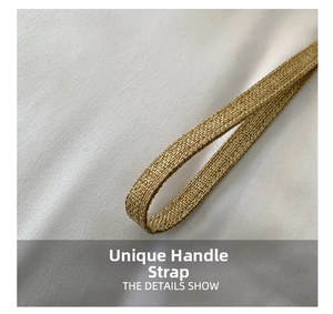 Macro detail of natural straw woven clutch bag strap featuring linen texture and tassels