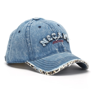 Close-up of distressed denim baseball cap with MCCANN letter embroidery and leopard brim