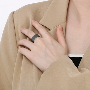 Close-up of black mesh woven titanium steel ring worn on hand with minimalist aesthetic