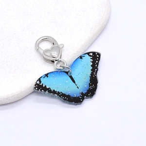 Macro detail of blue butterfly keychain with glitter acrylic and heart lobster clasp