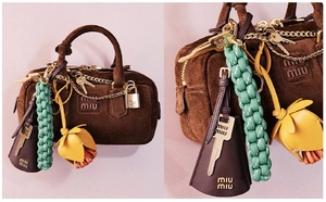 Detail of handmade woven colorful key-shaped charm and leather flowers on a handbag